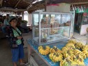 this woman sells fresh bananas and fresh donuts. the ideal shop!