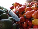 tropischer obststand: grüne mangos (mangifera indica), cashew-nüsse (anacardium occidentale) und ein angeschlagenes messer || foto details: 2011-02-10 02:15:18, costa rica, DSC-F828.