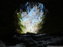 the glow worm cave entrance, seen through a puddle