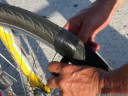 improvised bike repair, macgyver style: dad fixes the back tyre using a plastic bottle and insulating tape.